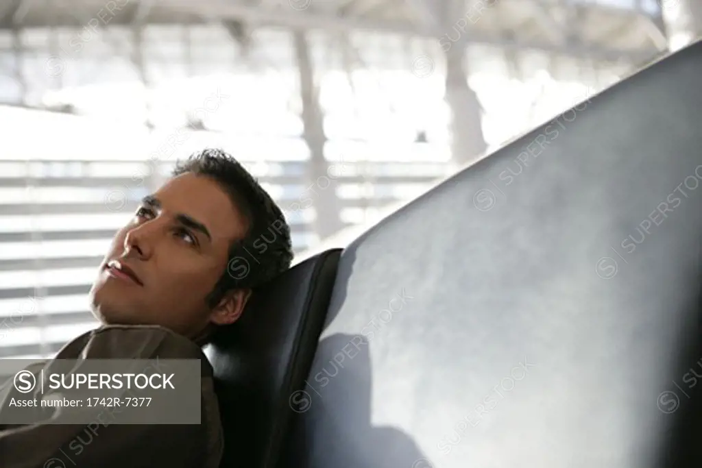 Young businessman relaxing in airport.