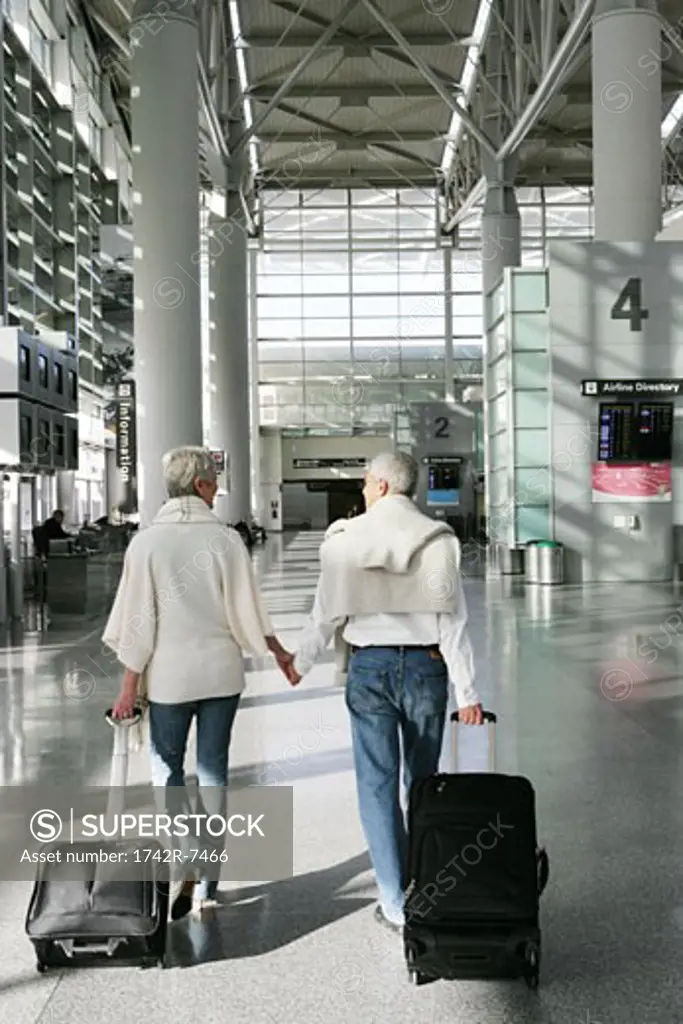Mature couple walking in airport.