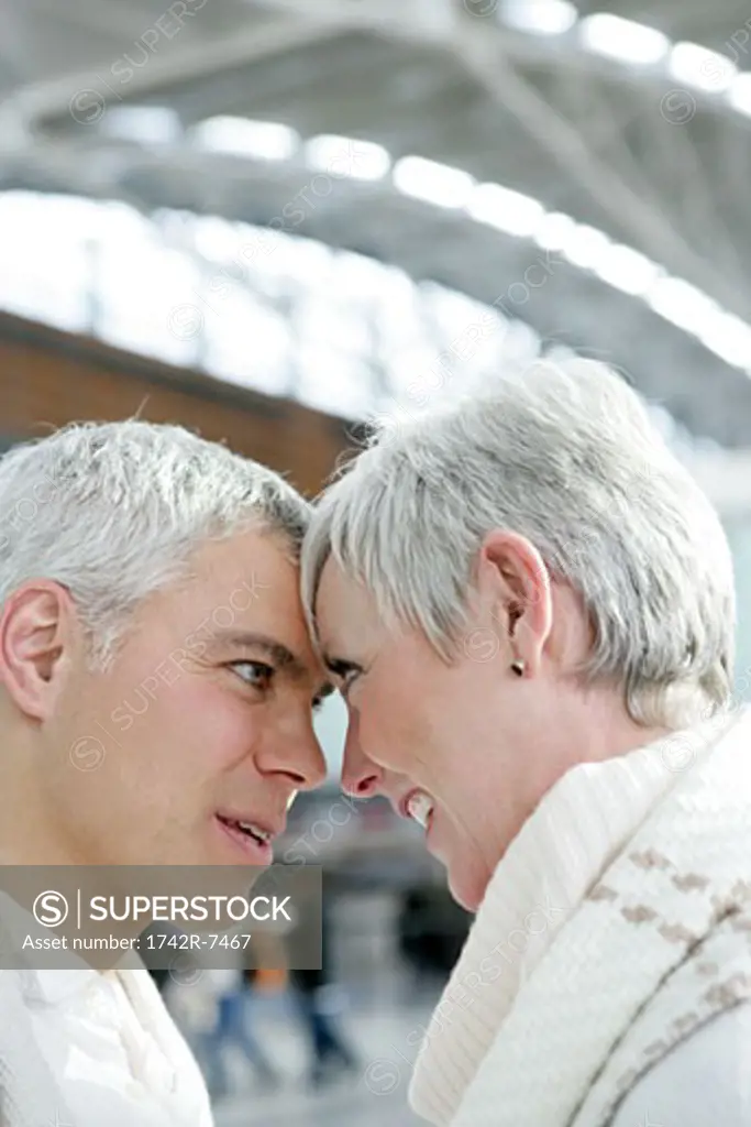 Mature couple looking at each other in airport.