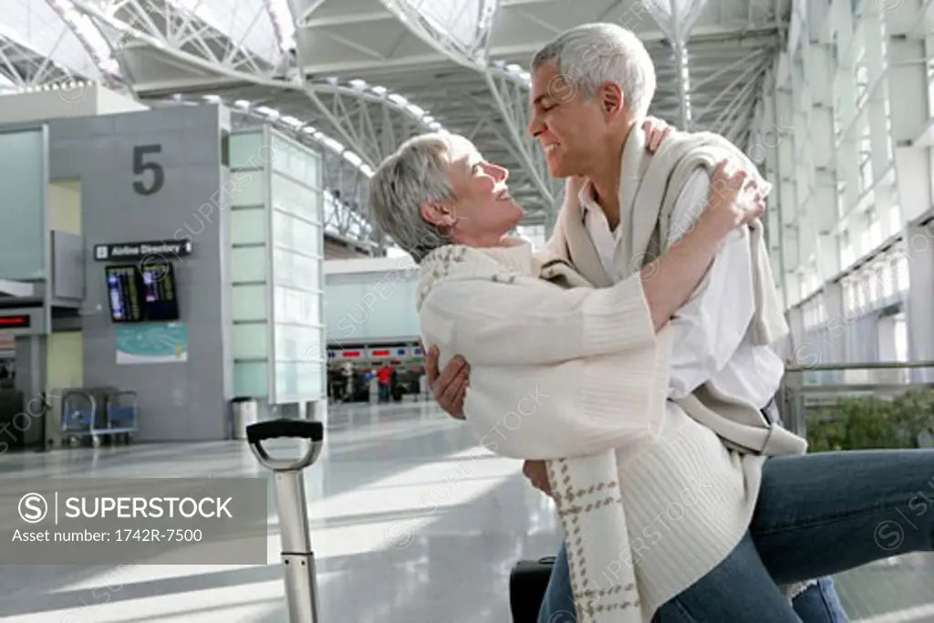 Romantic mature couple dancing in airport.