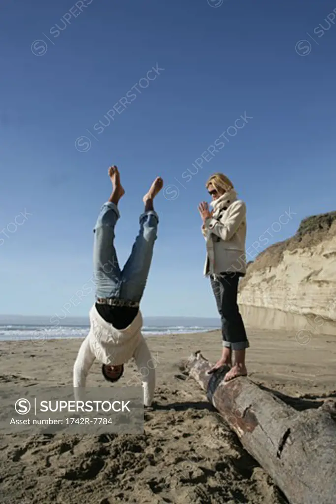 Young couple having fun at beach in winter.