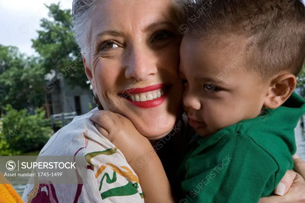 Close-up of a senior woman hugging her grandson