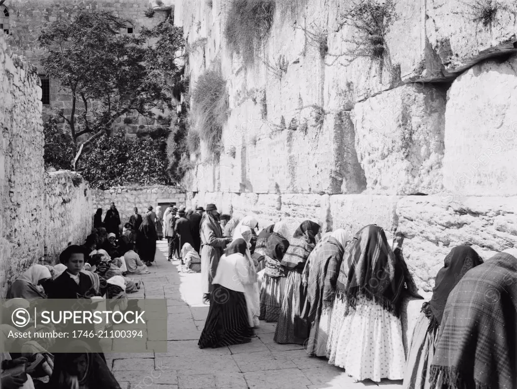 Photograph of Jewish men, women and children praying at the Western Wall, Jerusalem. Dated 1910