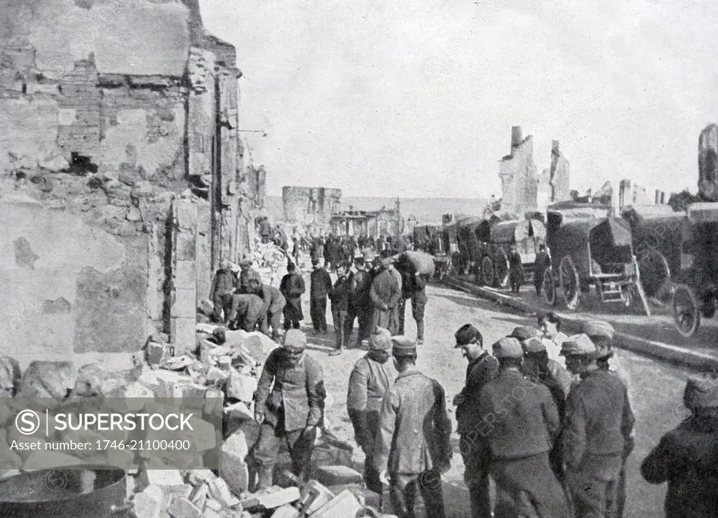 Photograph of German Prisoners of War helping to clear rubble at Clermont-en-Argonne, North-eastern France. Dated 1916