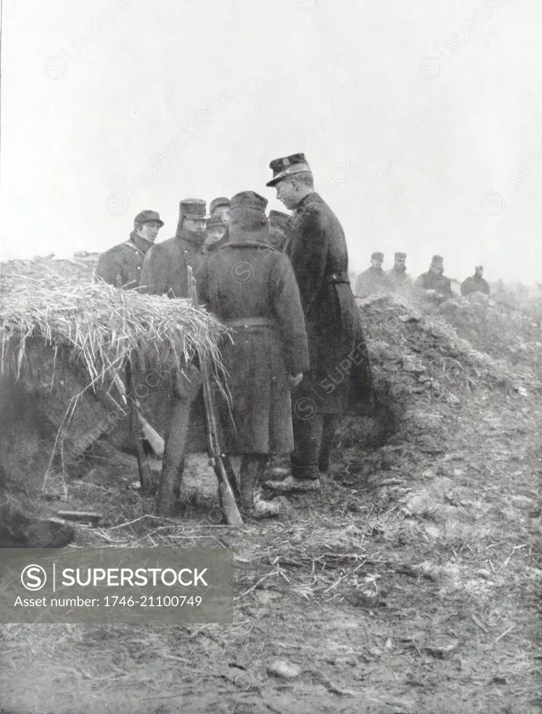 Photograph of King Albert I of Belgium vesting his troops in the trenches during World War One. Dated 1914