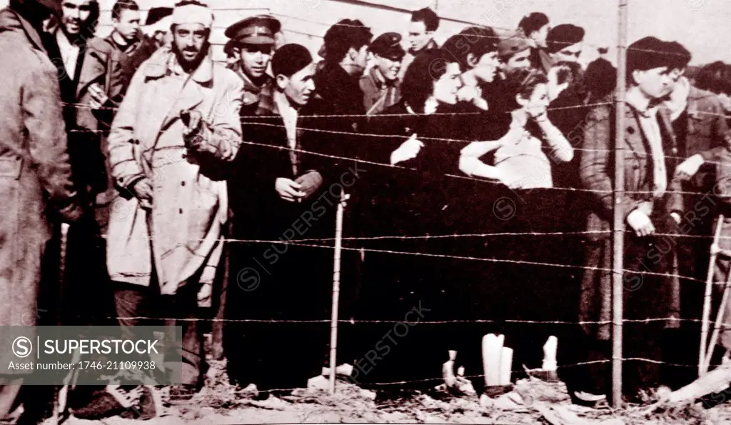 Spanish Republican Refugees (soldiers and Civilians) stare from behind barbed wire, in a detention camp in France after the Nationalists seize control of Spain in 1939 following the end of the Spanish Civil War