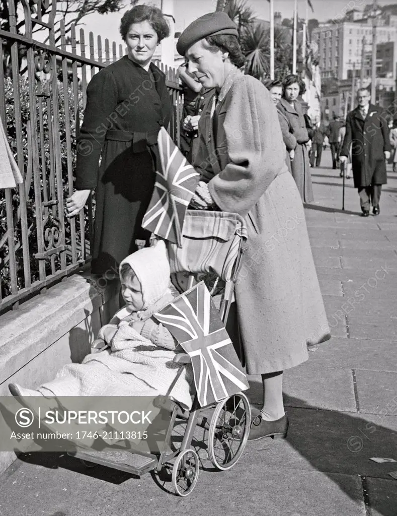 World War two: Women, with a child in a pram, standing near the government buildings, Wellington, New Zealand, on VE day, May 1945