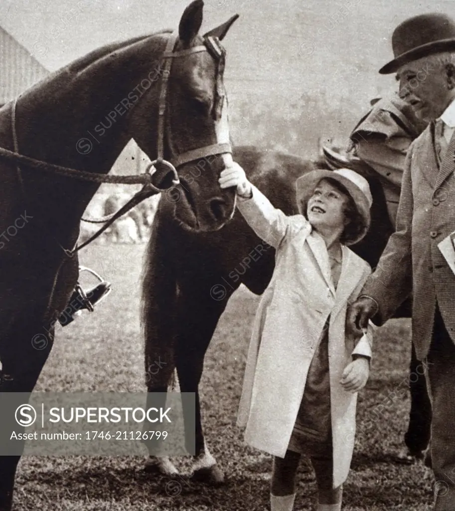 Photograph of Princess Elizabeth (1926-) stroking a winning horse at the Richmond Horse Show. Dated 20th Century