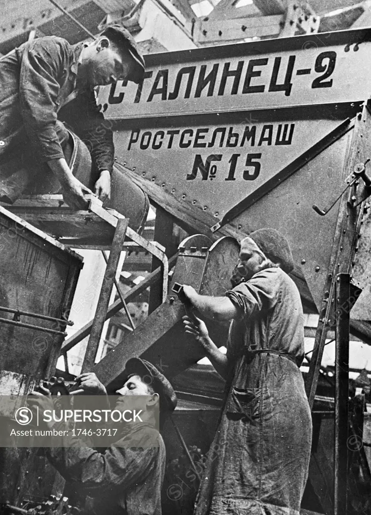 Men and women at work on a combine harvester in a factory at Rostov-on-Don, Union of Soviet Socialist Republics (USSR), 1930-1940. Russia