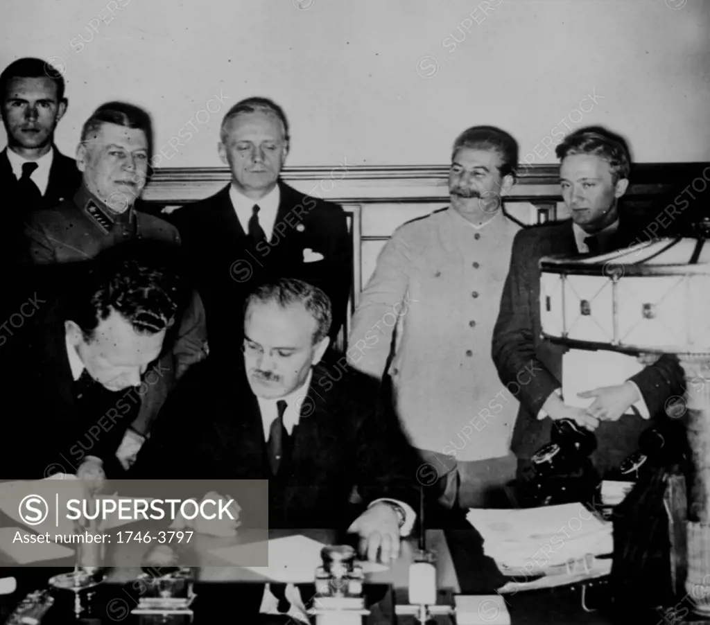 Soviet Foreign Commissar Vyacheslav Molotov signs the German-Soviet nonaggression pact; Joachim von Ribbentrop and Josef Stalin stand behind him. Moscow, August 23. 1939.World War II