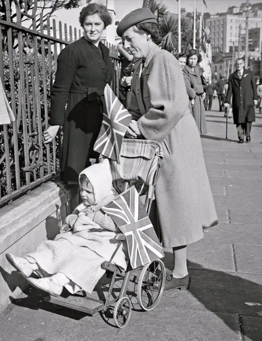 World War two: Women, with a child in a pram, standing near the government buildings, Wellington, New Zealand, on VE day, May 1945