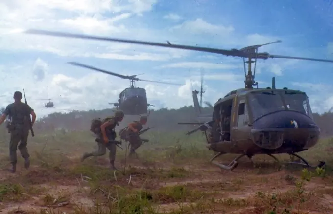 Photograph of American troops running towards a chopper during the Vietnam War. Dated 1970