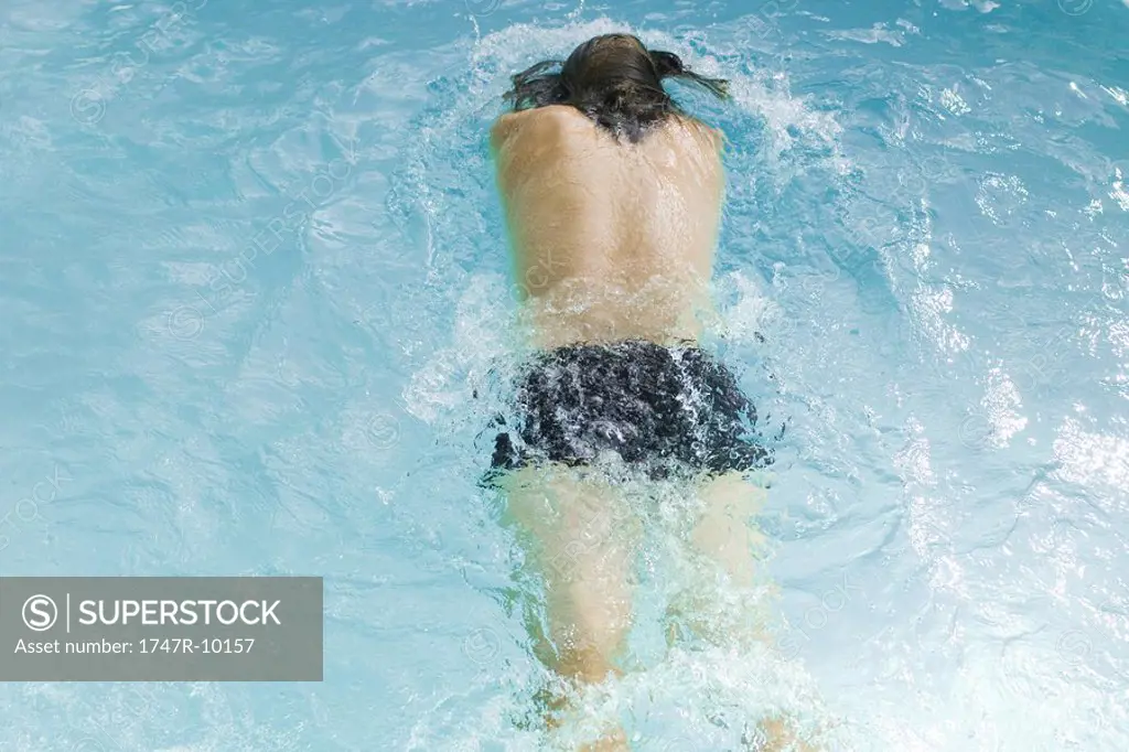Man swimming in pool, rear view