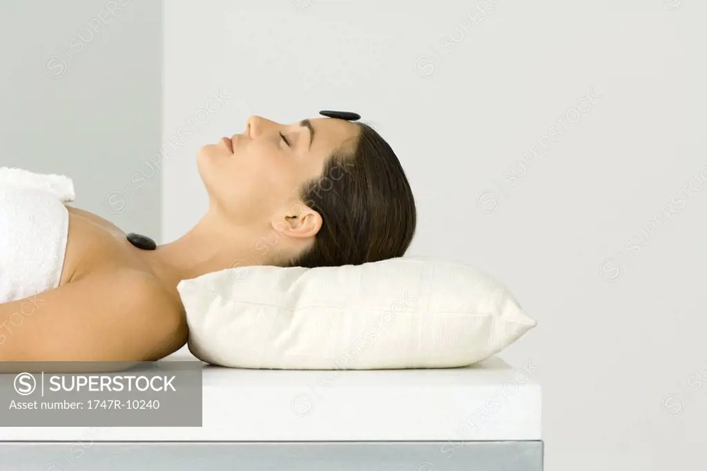 Woman receiving lastone therapy, eyes closed