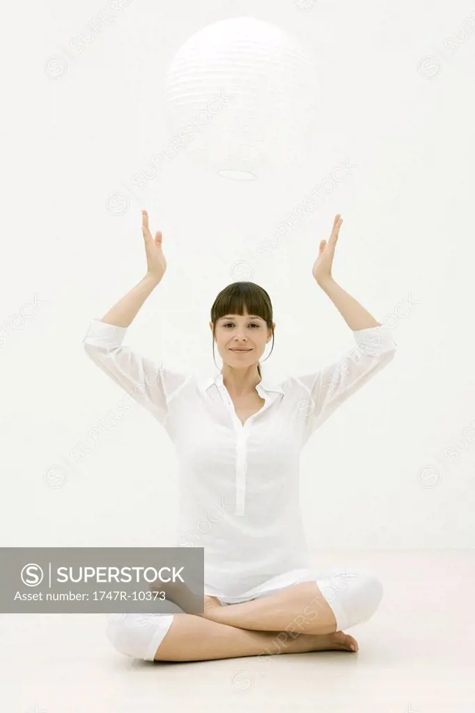 Woman meditating with sphere over head