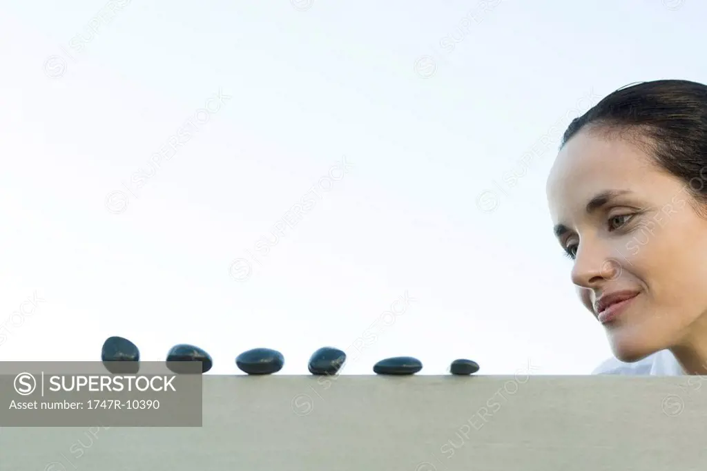 Woman looking at line of pebbles