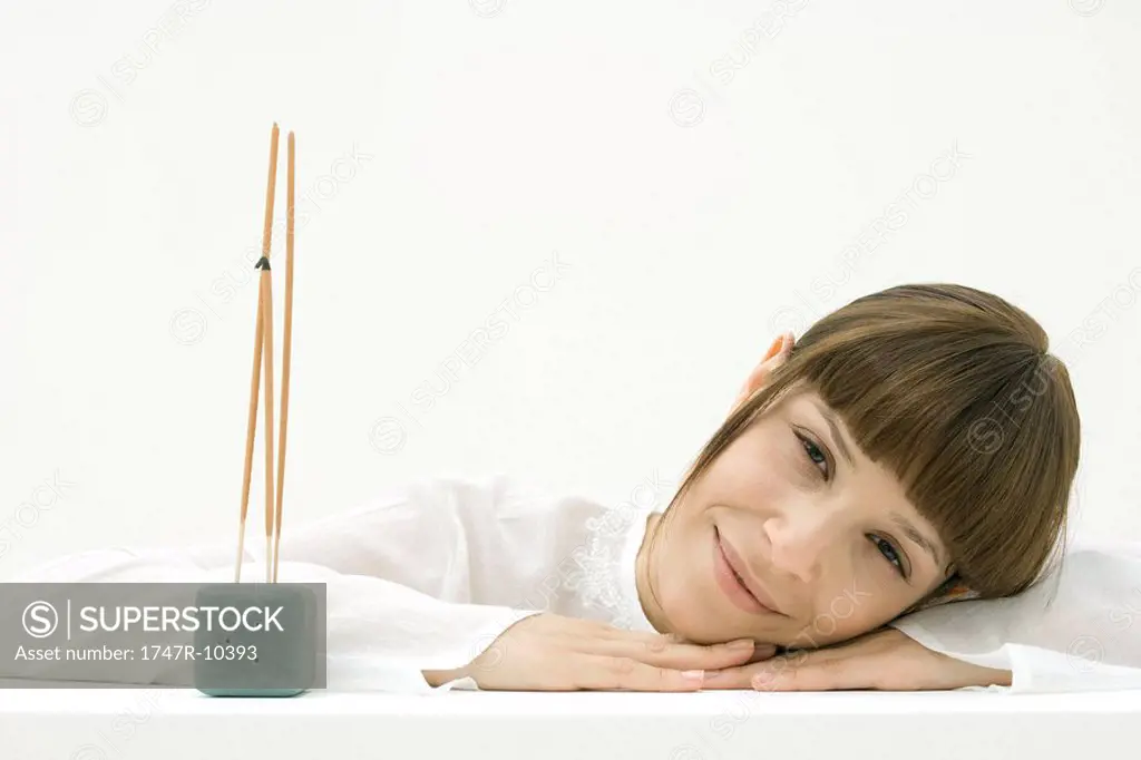 Woman with incense, smiling at camera