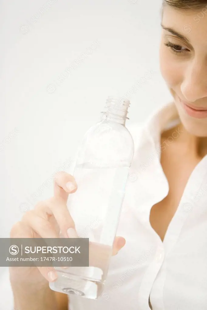 Woman holding bottle of water, cropped view