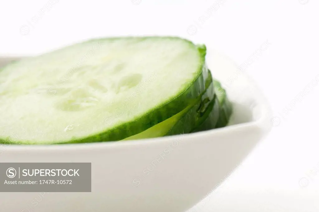 Cucumber slices piled in small dish, close-up