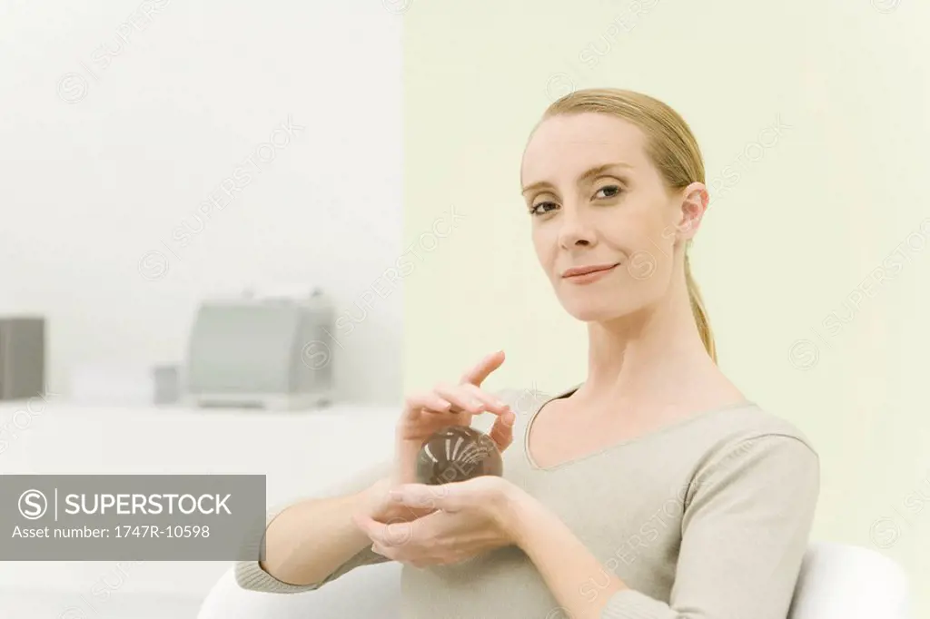 Professional woman holding crystal ball, smiling at camera