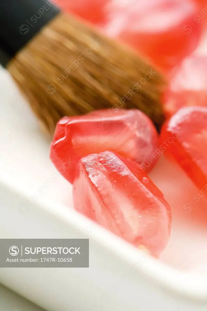 Fresh pomegranate seeds and make-up brush, extreme close-up