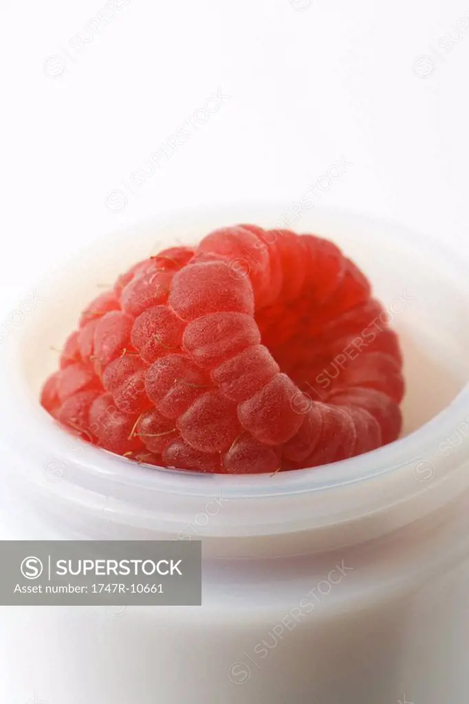 Ripe raspberry in small jar