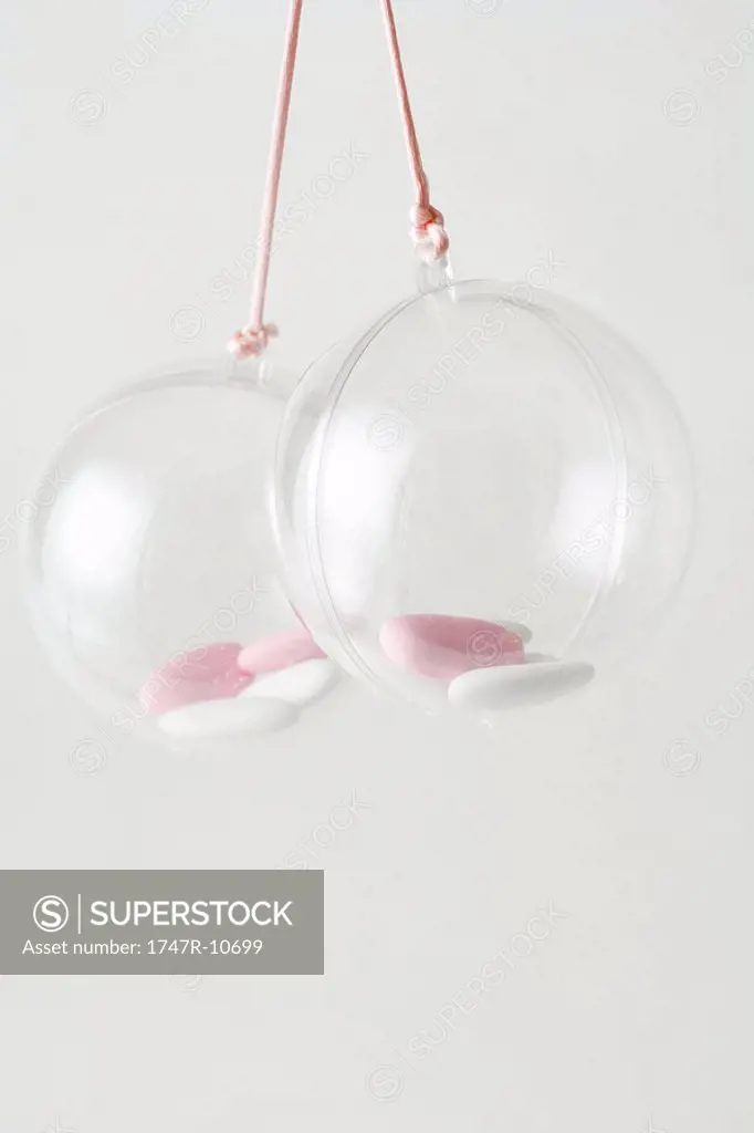 Pair of glass ornaments containing candy, close-up