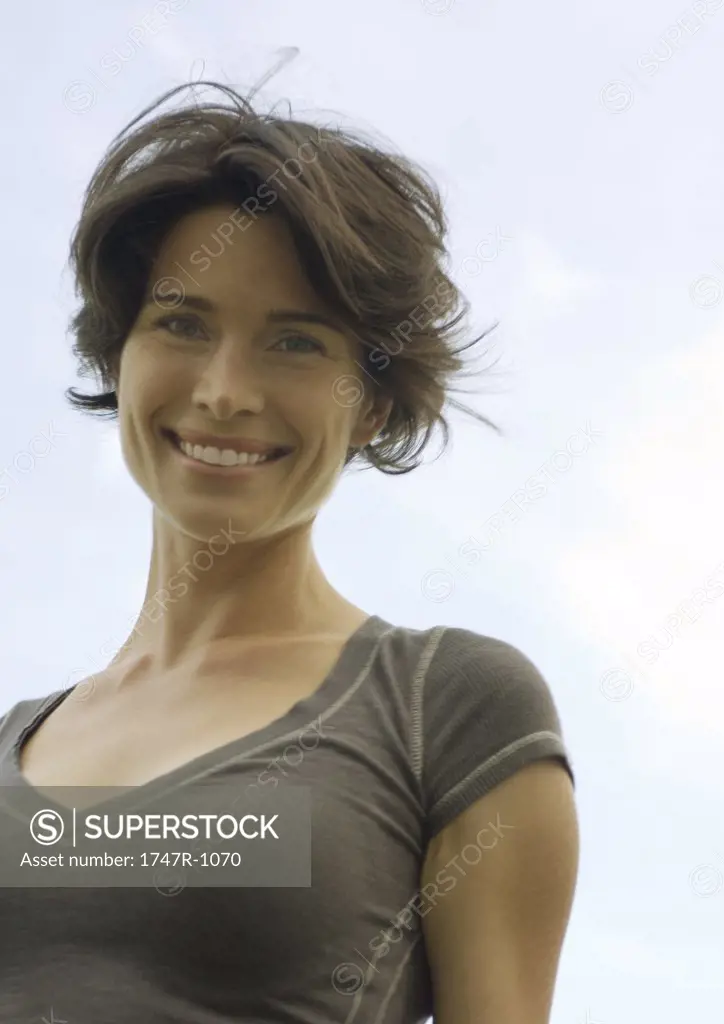 Woman smiling at camera, portrait, sky in background