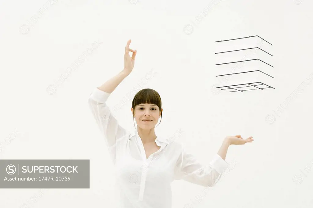 Woman with arms raised, hands underneath and to the side of box in midair, smiling at camera