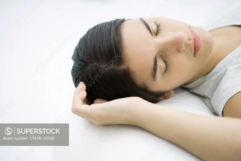Teenage girl lying down, eyes closed