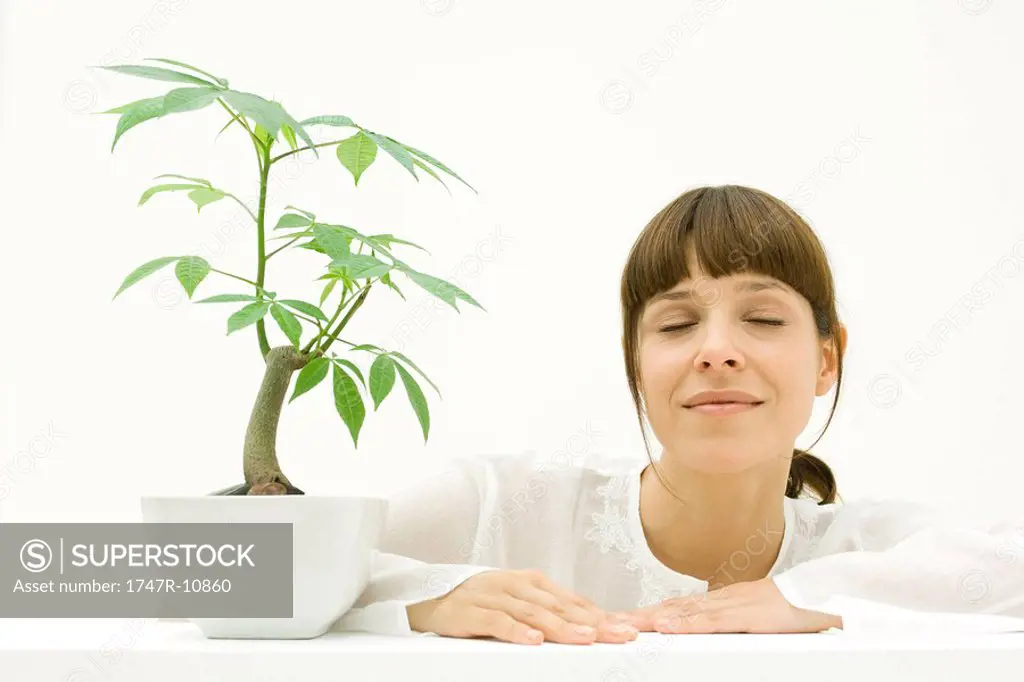 Woman relaxing next to potted plant