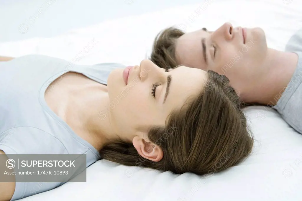 Couple sleeping, heads side by side
