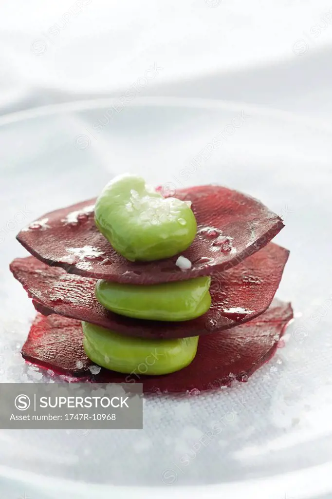 Stack of broad beans on slices of beet