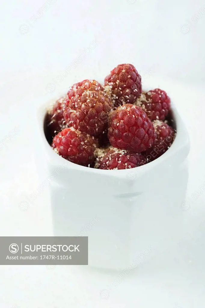 Raspberries sprinkled with sugar in porcelain jar