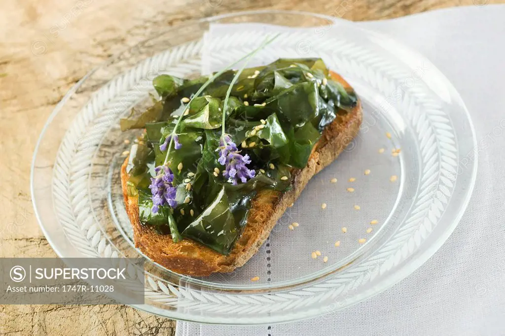 Seaweed on toast, garnished with sesame seeds and lavender flowers
