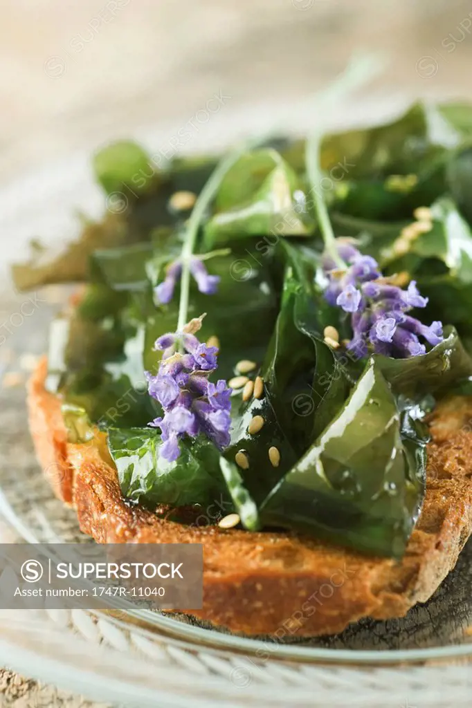Toast topped with seaweed and sesame seeds, garnished with lavender flowers