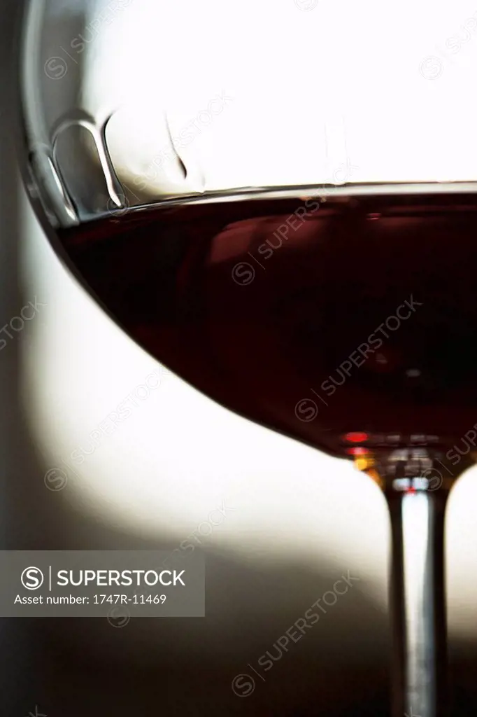 Red wine, bowl of wineglass displaying tears of wine, close-up
