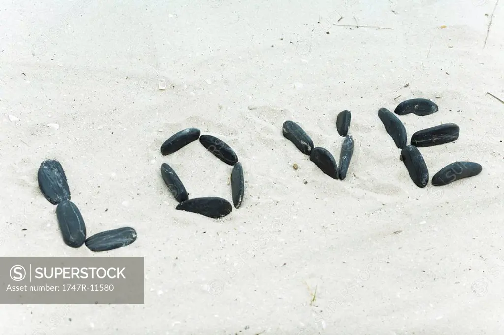 Pebbles spelling the word love on beach