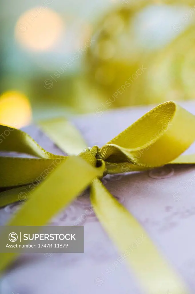 Gold ribbon tied in bow around gift, extreme close-up