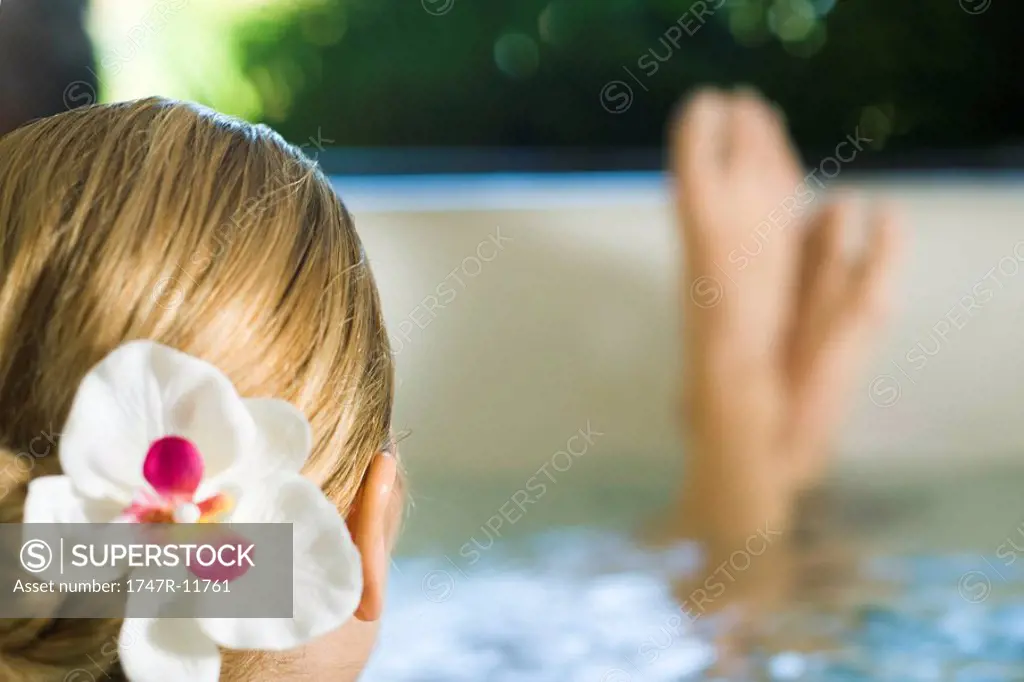 Woman soaking in spa, cropped view