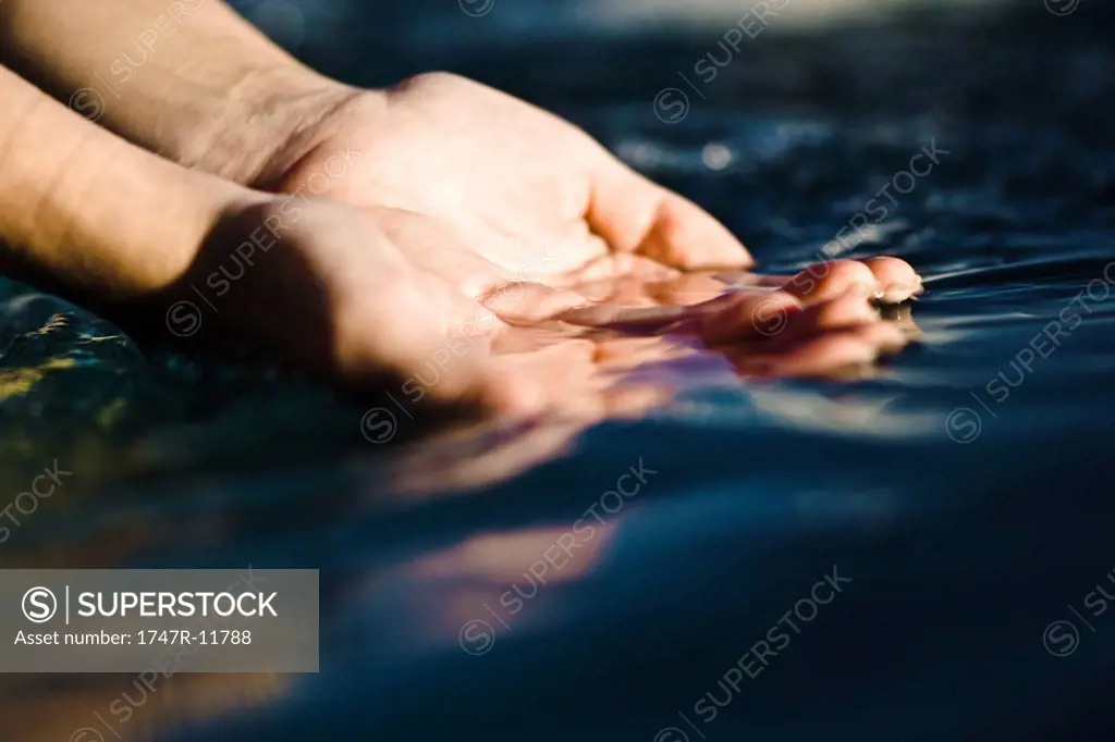 Cupped hands catching water