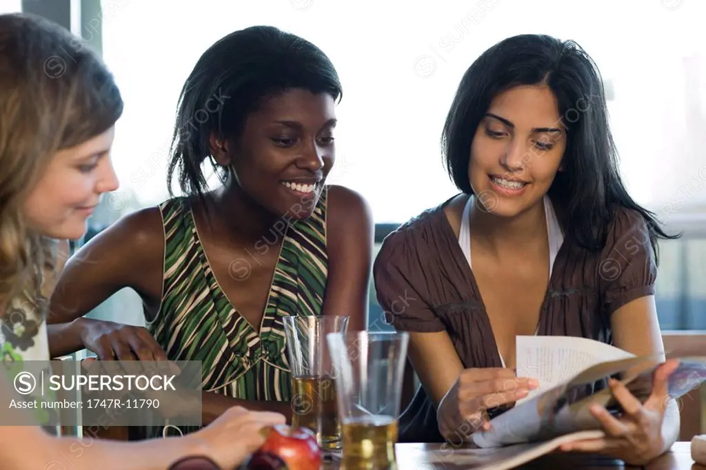 Friends hanging out together looking at magazine