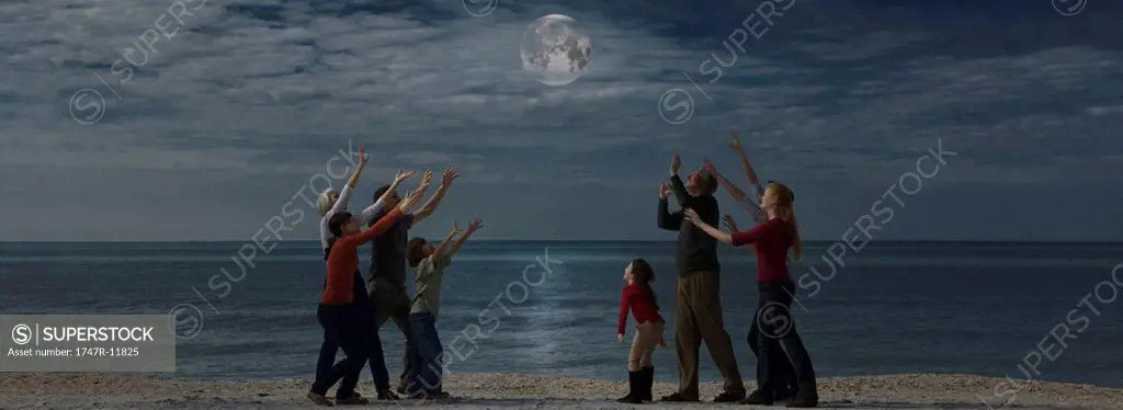 Group of people reaching for the moon
