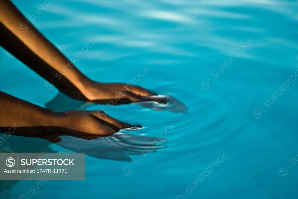 Hands in blue water