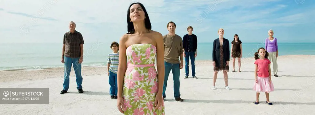 Woman with group of people on beach, eyes closed