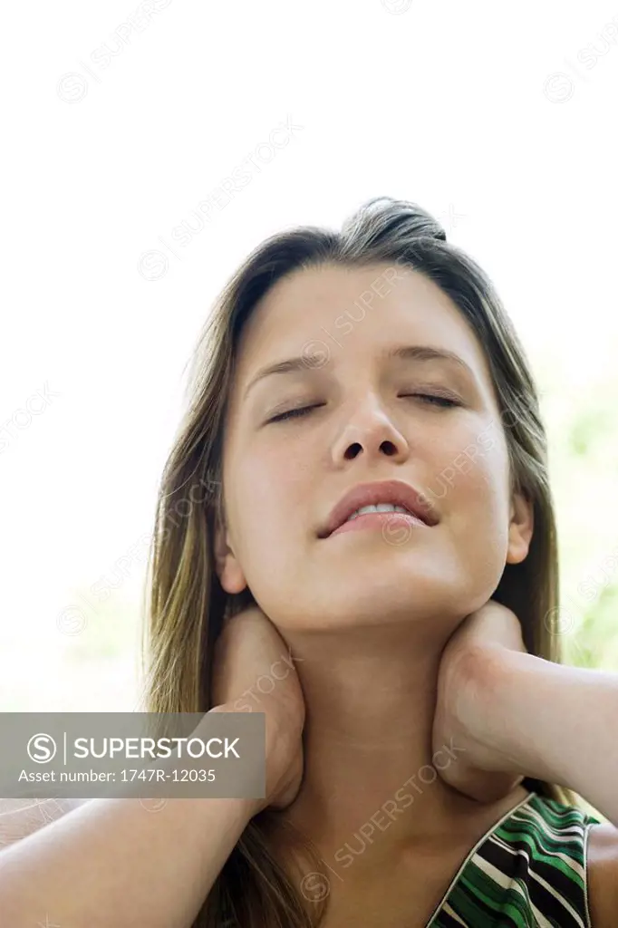 Young woman rubbing neck