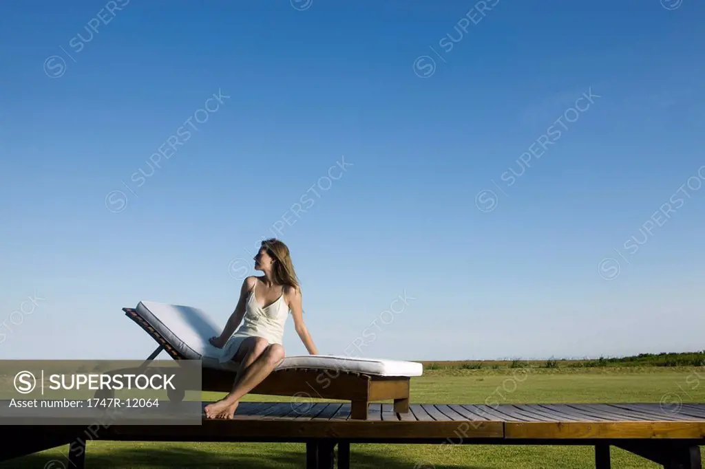 Woman relaxing on lounge chair outdoors