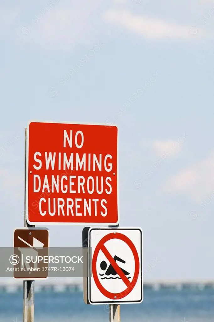 Signs prohibiting swimming due to dangerous currents and requiring dogs to be on leashes