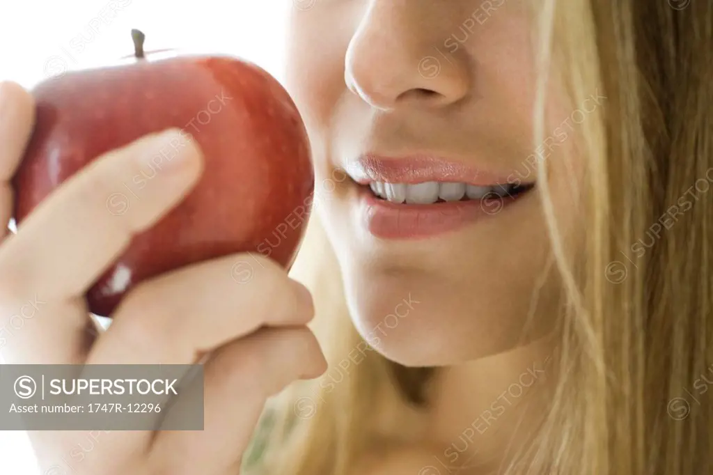 Young woman eating apple, close_up