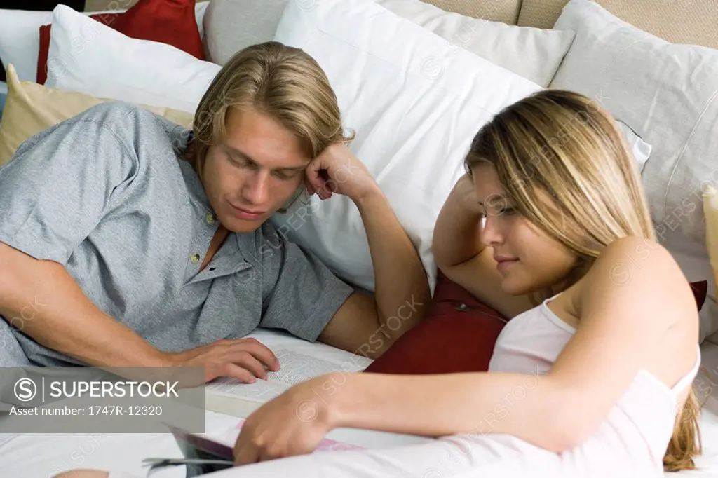 Young couple reading together in bed
